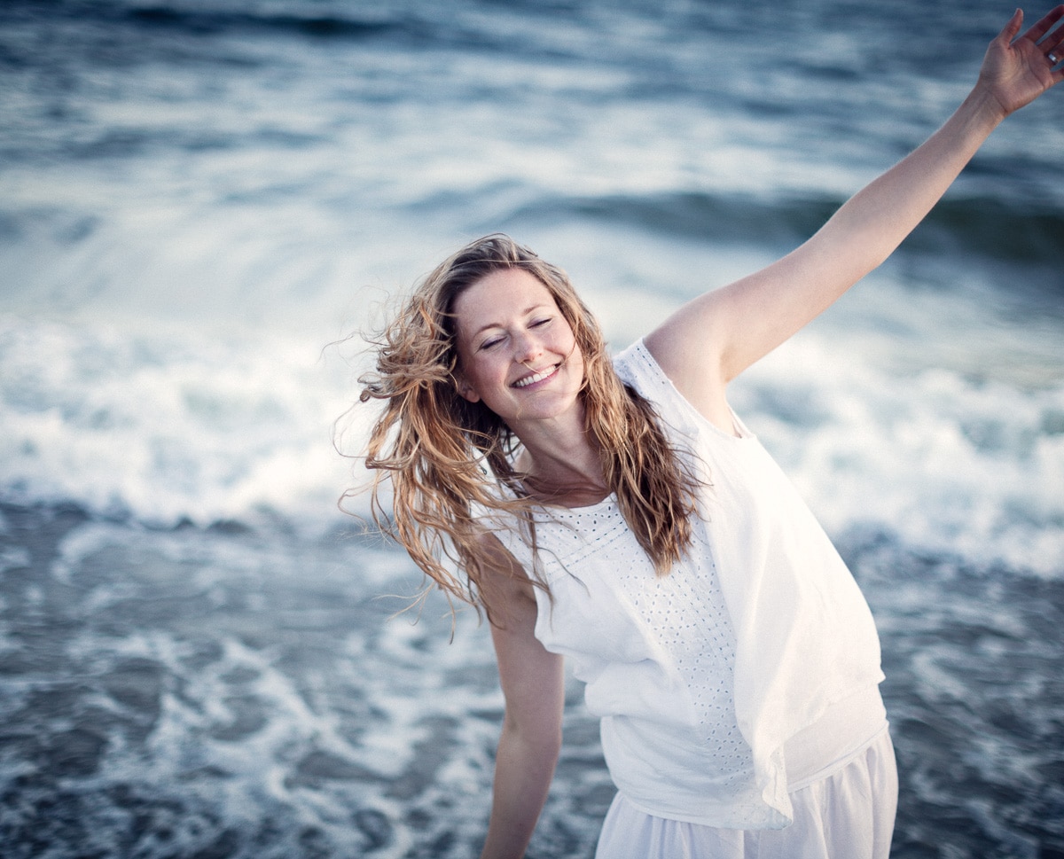 Glad yoga-tjej blundar på stranden i Örnsköldsvik